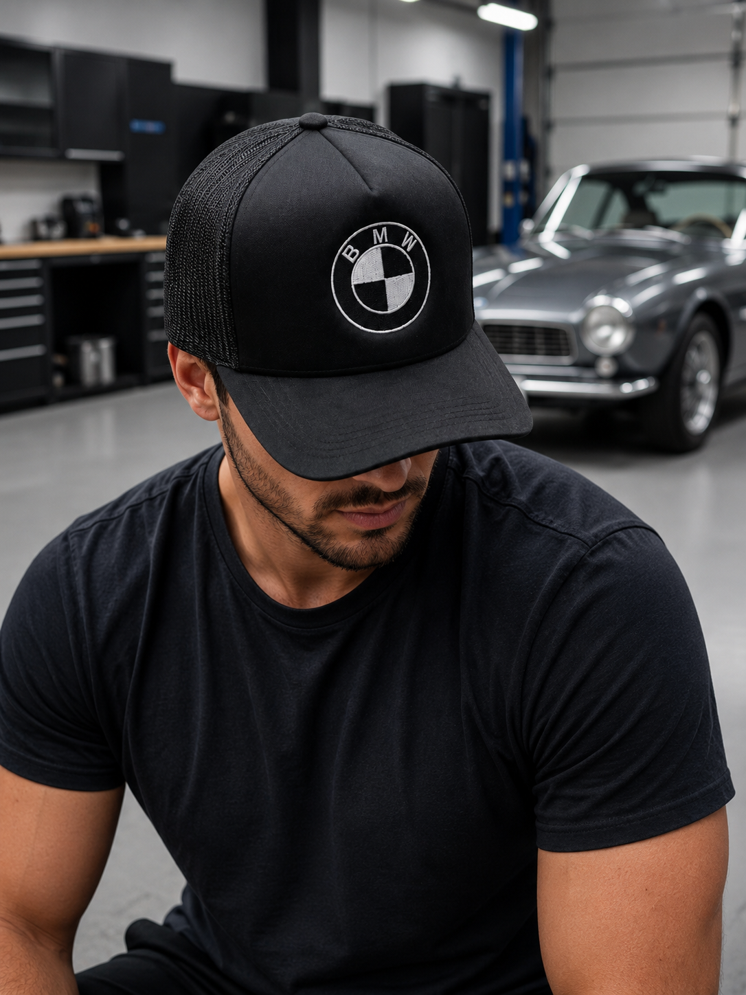 Black BMW embroidered foam trucker cap worn by a model, front and side view
