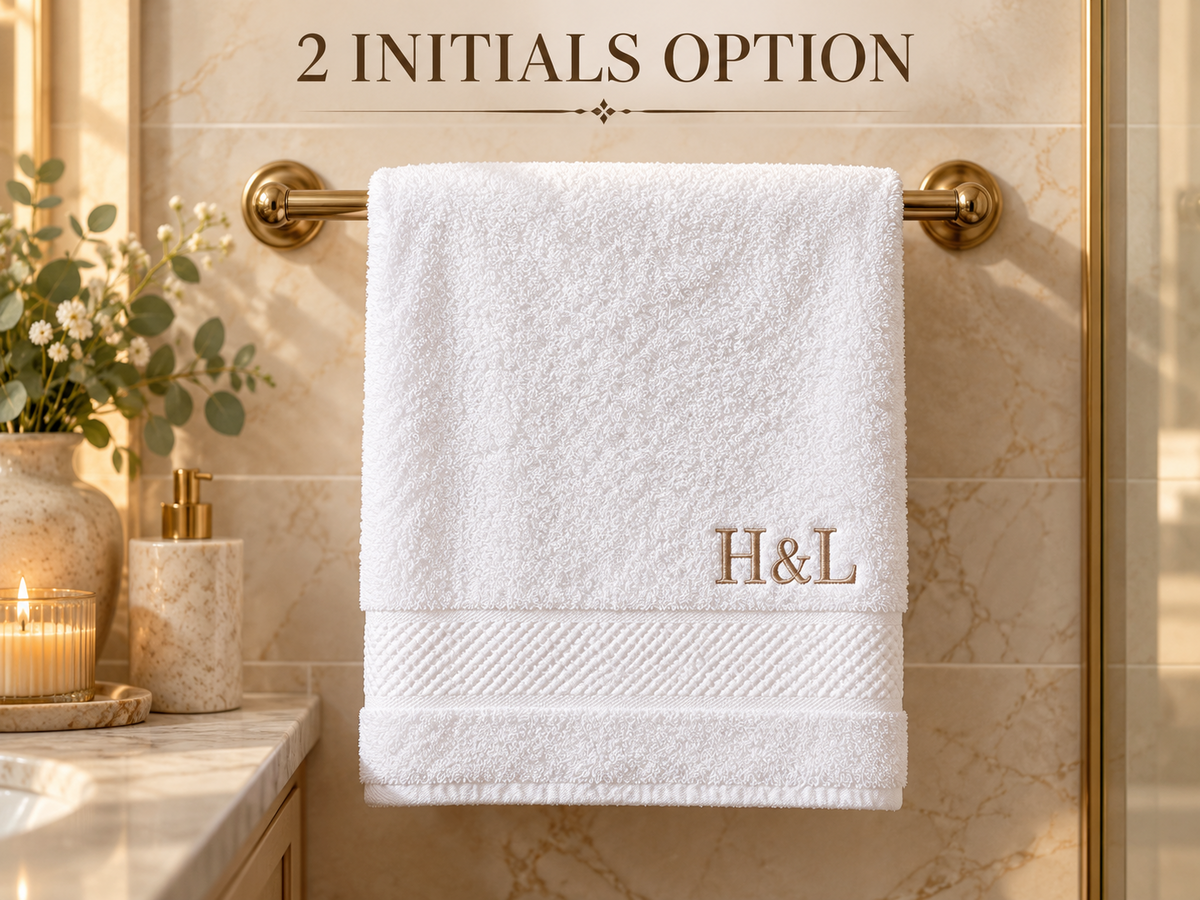 Two initials embroidered on white washcloth near decorative border