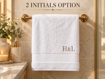 Two initials embroidered on white washcloth near decorative border